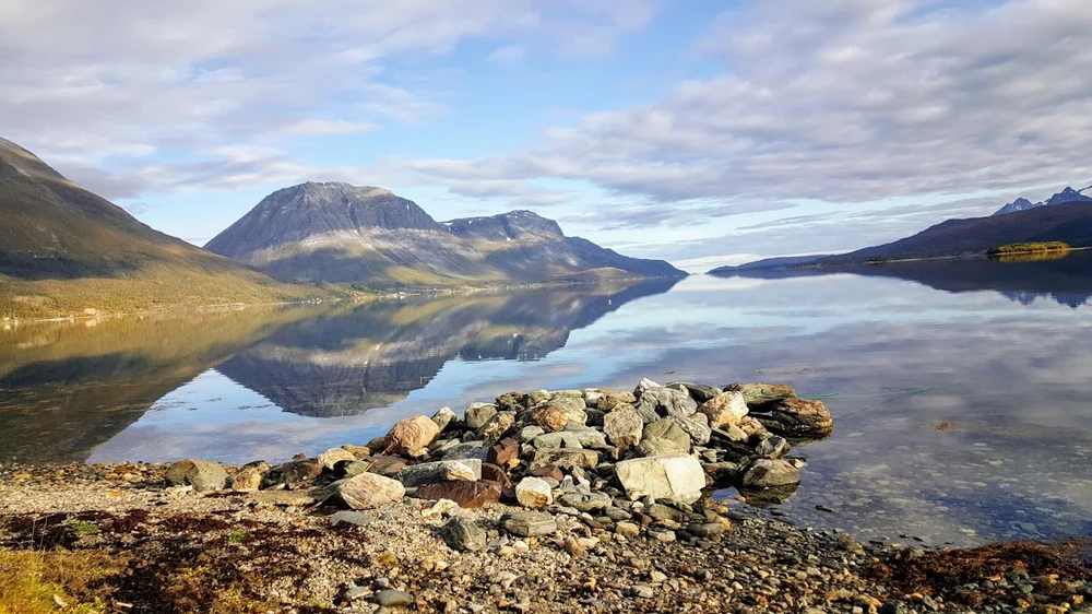 Et stille fjellvann med speiling av fjellene